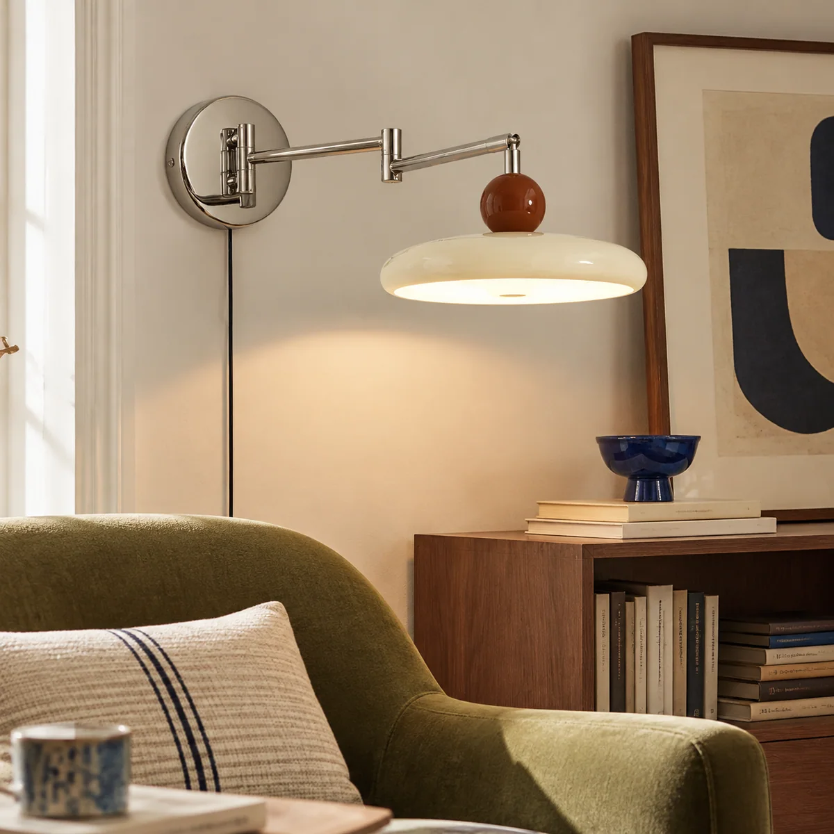 Drummond wall light with its two-part arm extended toward a reading chair