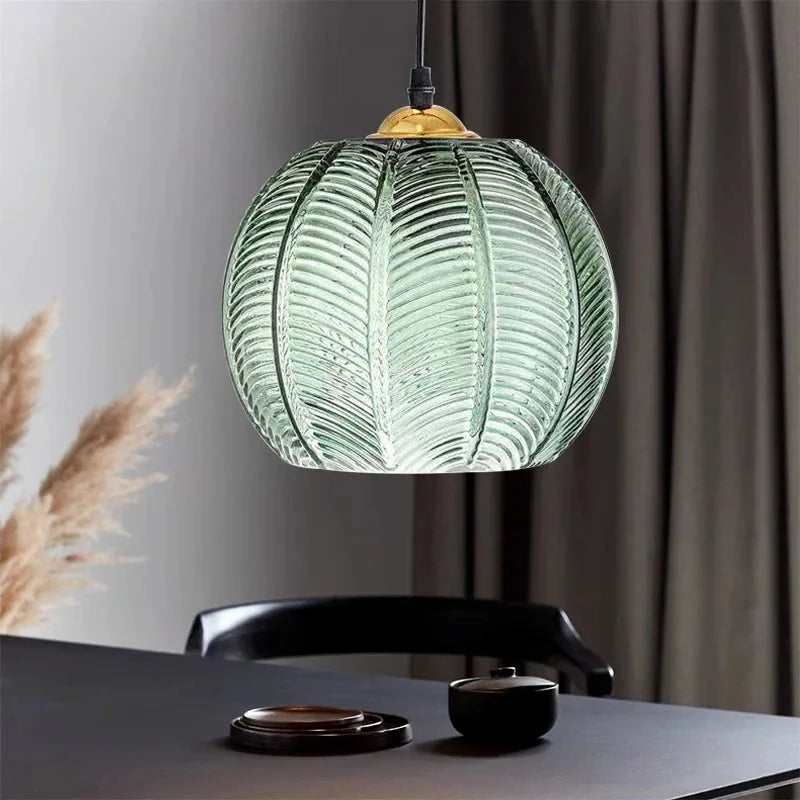 Lampadario a sospensione Gaia in vetro sopra un tavolo da pranzo scuro