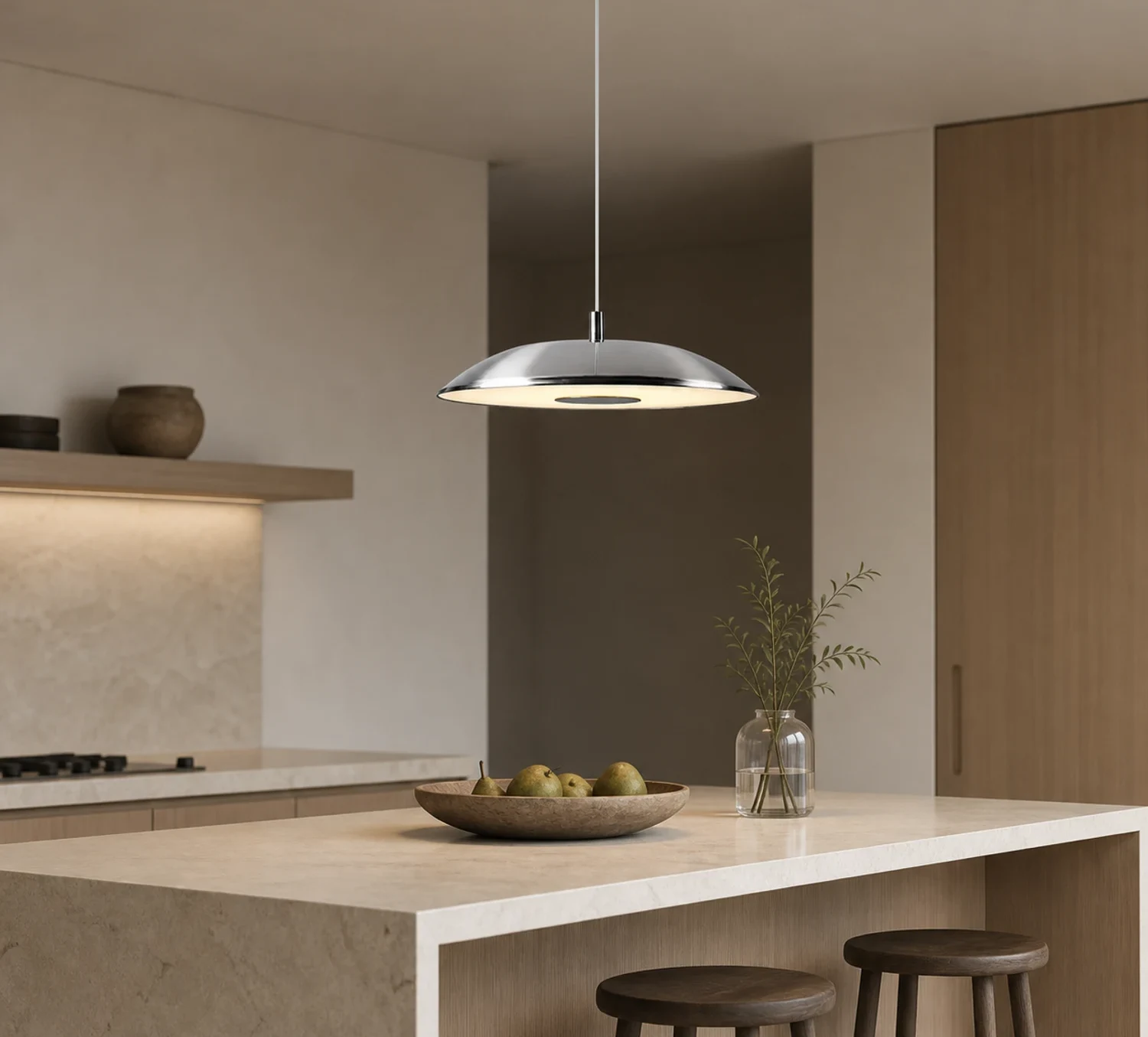 Lampadario a sospensione a forma di disco volante cromato sopra un'isola della cucina.