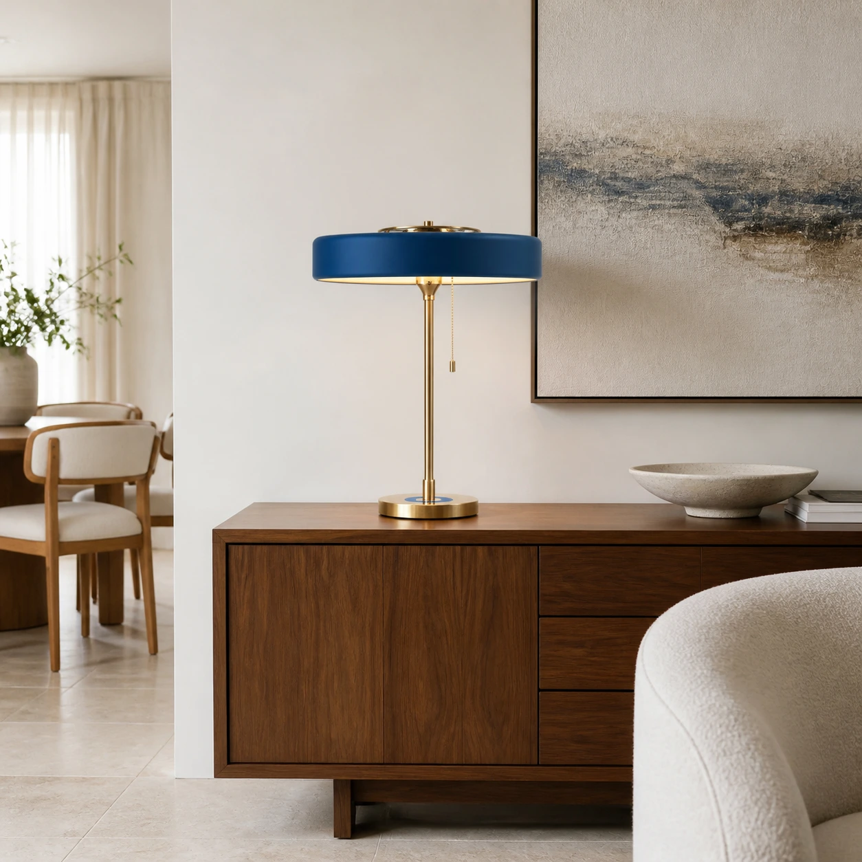 Blue mid-century round table lamp on a walnut sideboard in a refined living room
