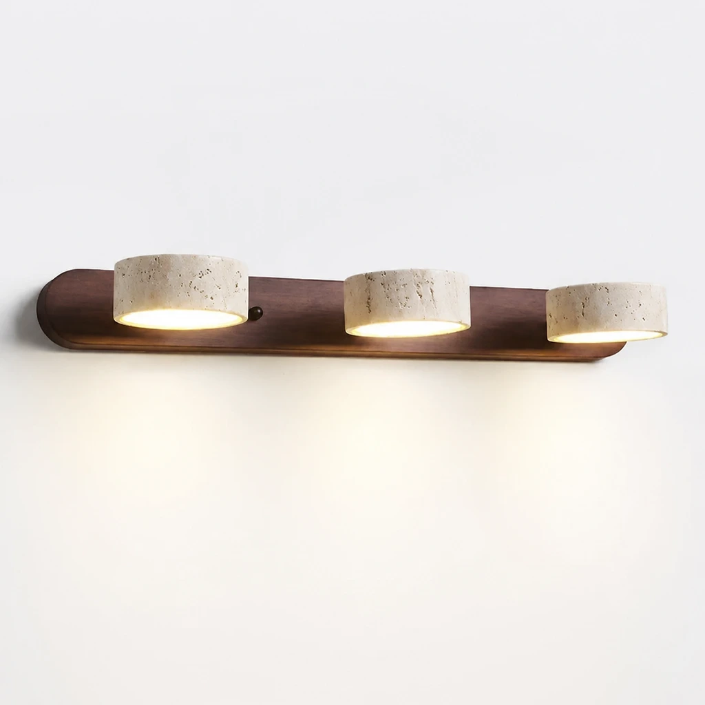 3-light wall sconce switched on against a white studio wall
