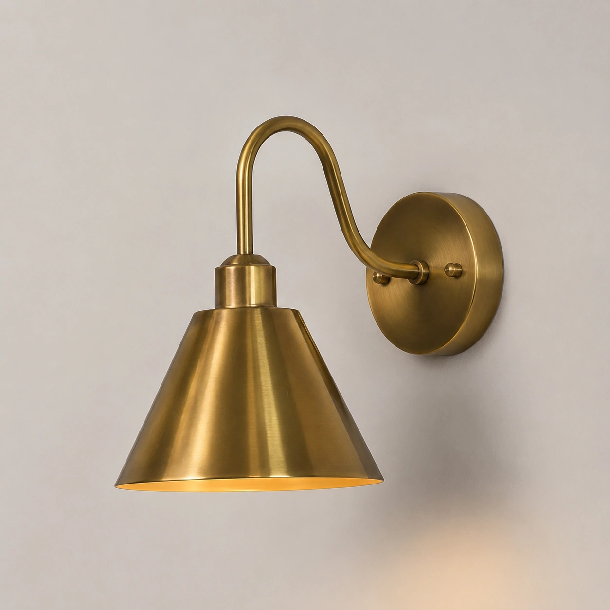 Vintaged Brass Penia wall sconce on a light studio wall