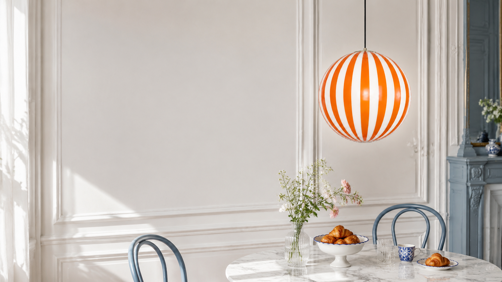 Mireille orange striped glass globe pendant in a bright French dining nook
