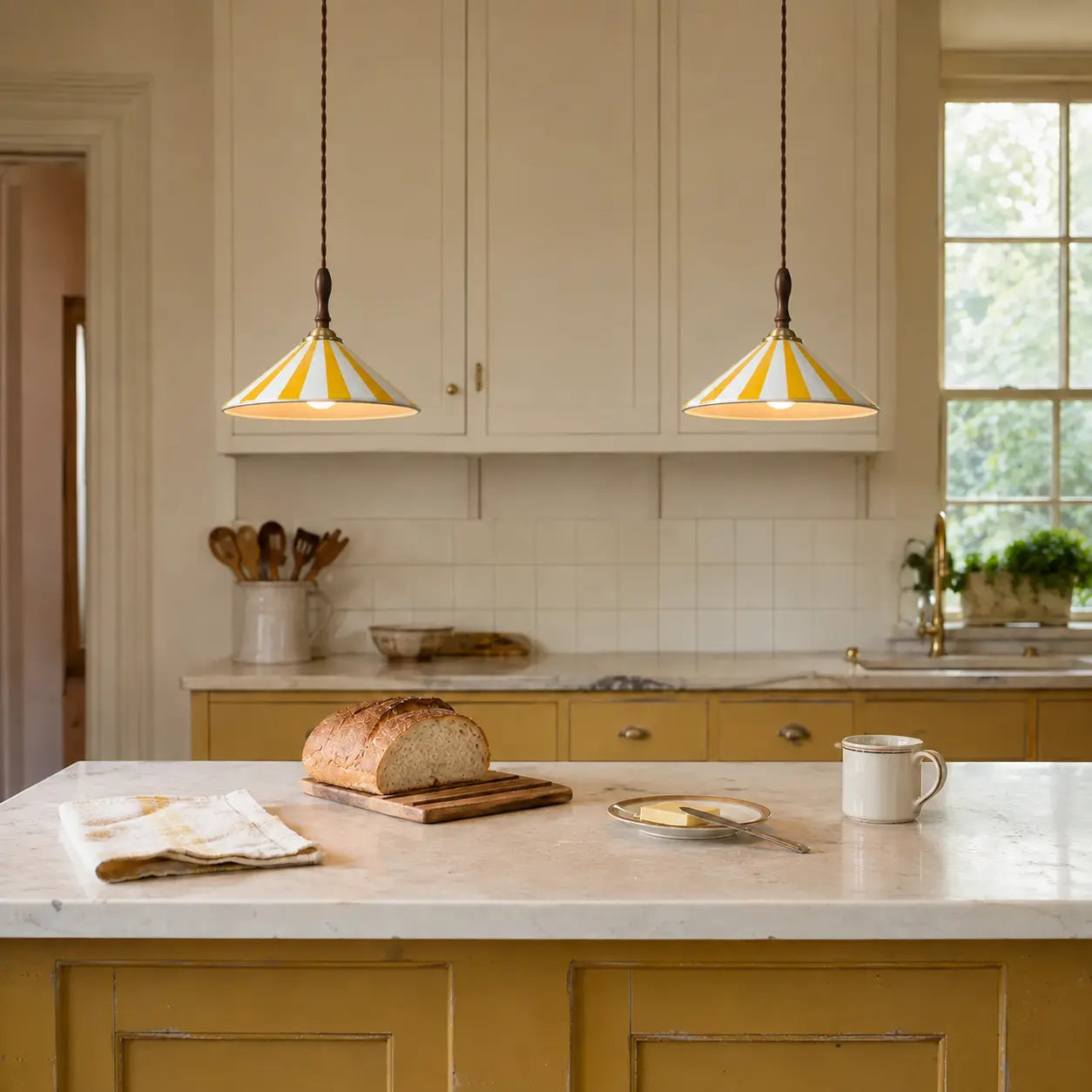 Two yellow Solenne pendants at equal height above a lived-in kitchen island