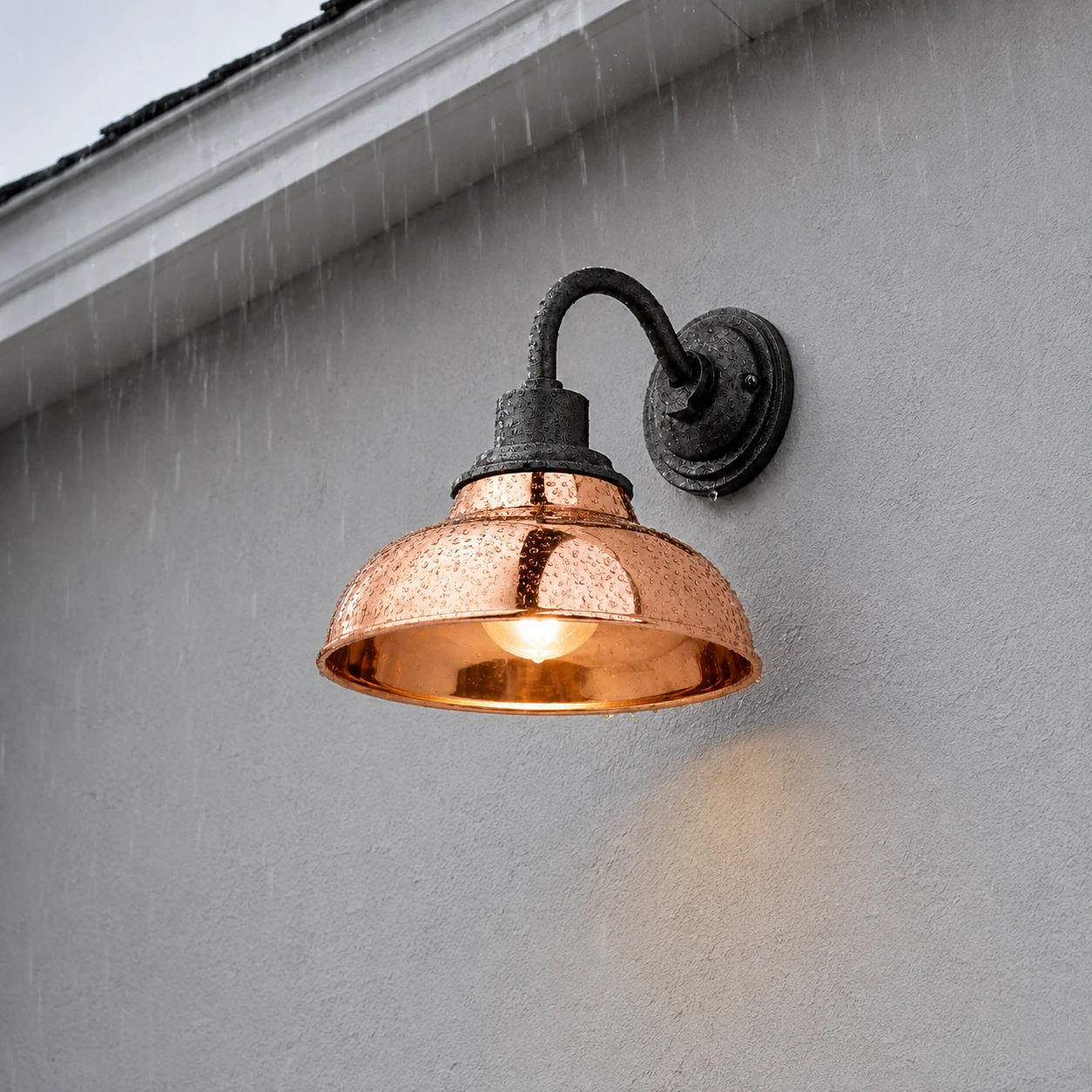 Illuminated Rowen wall sconce high on a rainy exterior side wall