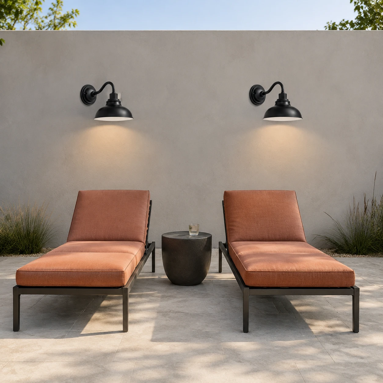 Two illuminated Rowen wall sconces above a furnished outdoor lounge terrace