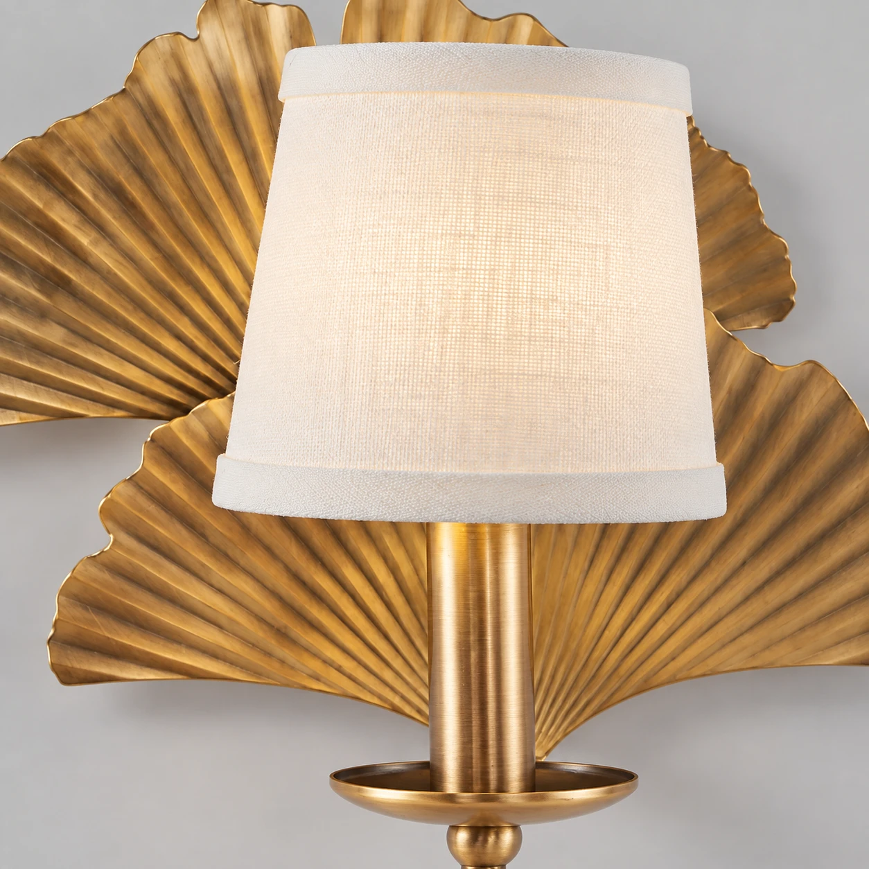 Close-up of the white fabric shade and copper wall sconce fitting