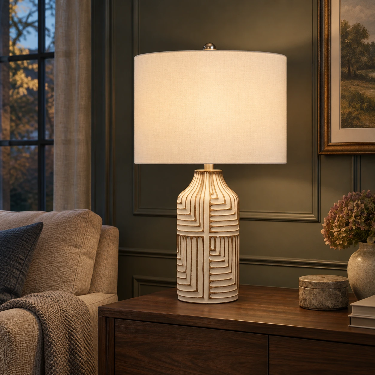 Odette table lamp switched on in a charcoal-green evening lounge