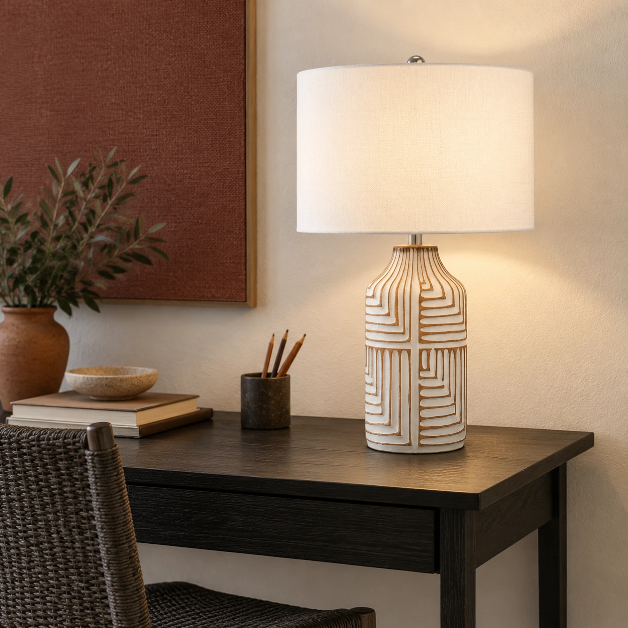 Odette table lamp on an ebonized writing desk with a muted clay-red wall panel