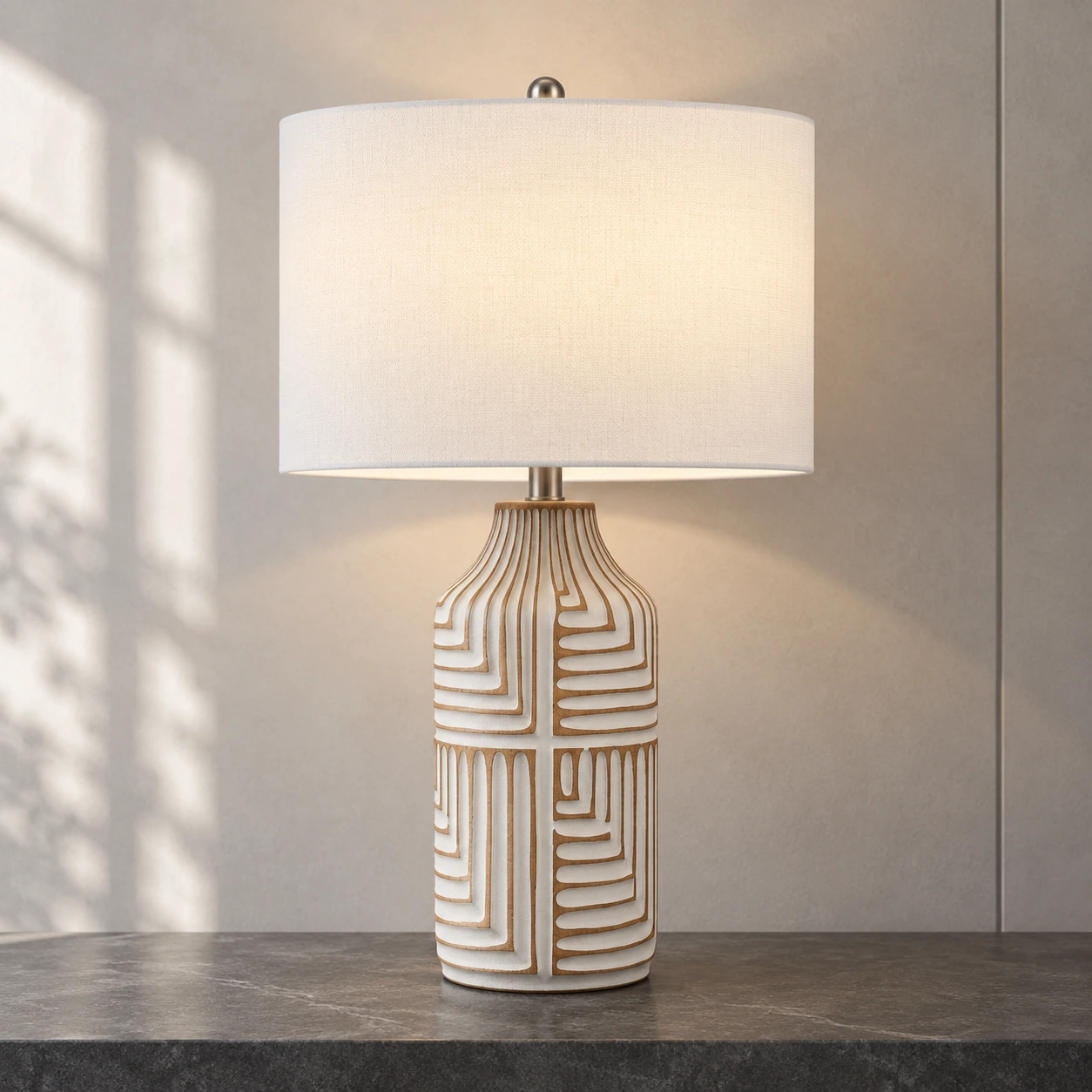 Odette carved wood table lamp switched on against a pale smoke-gray mineral wall