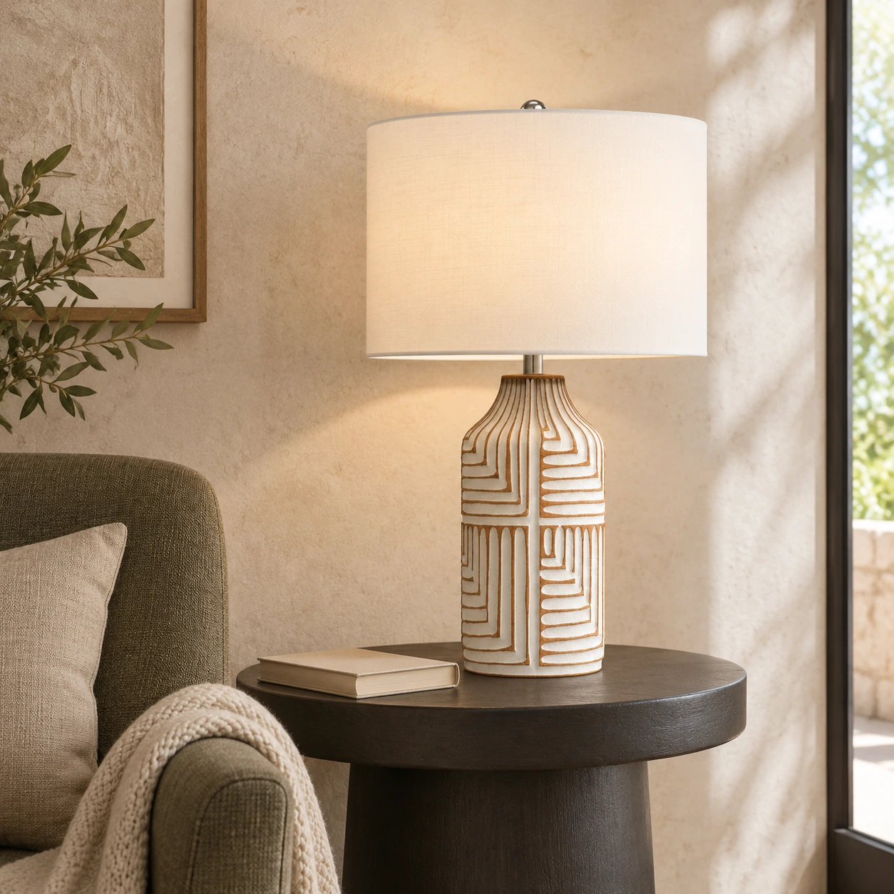Odette table lamp beside an olive-gray chair in a limestone reading corner