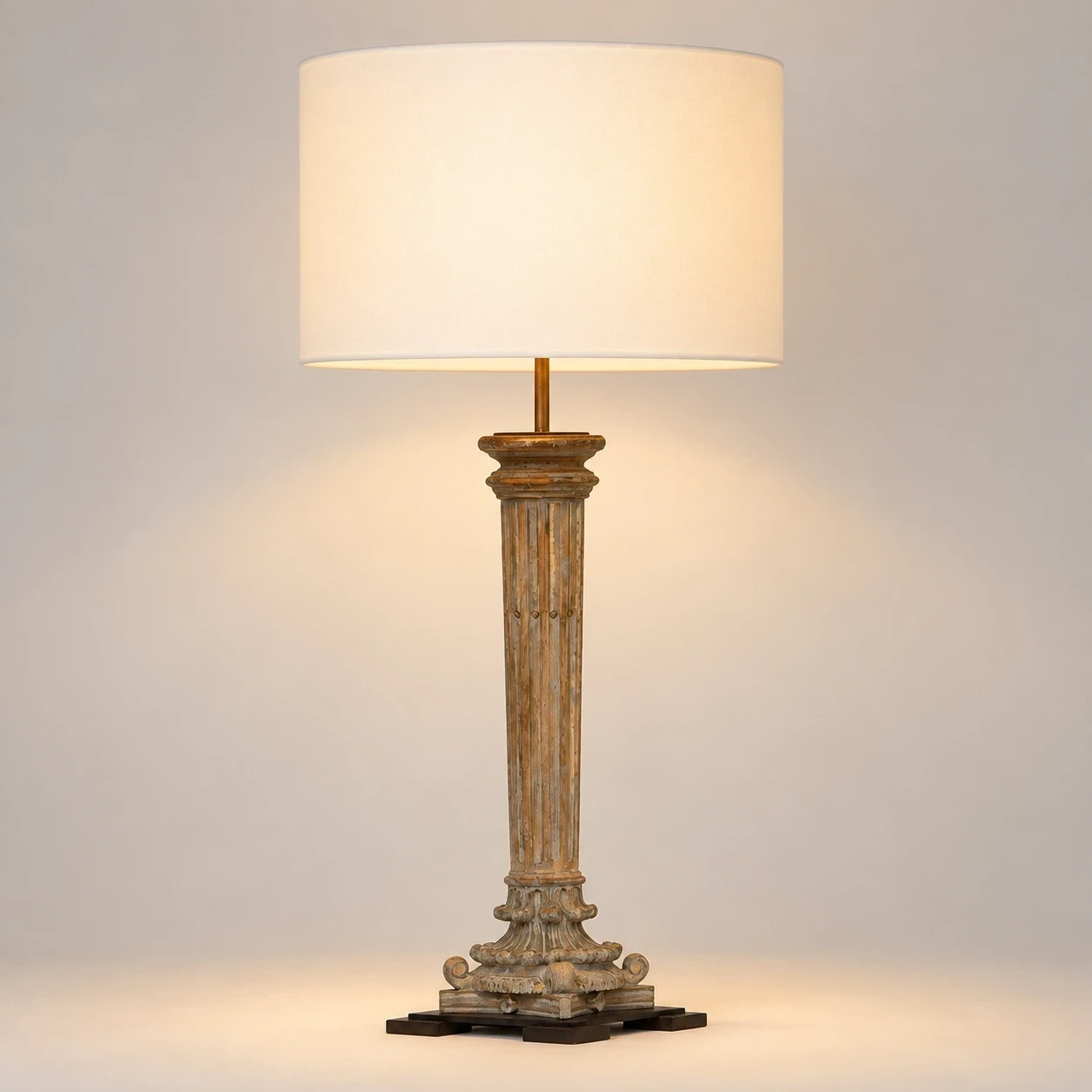 Aveline carved wood table lamp illuminated in a neutral studio