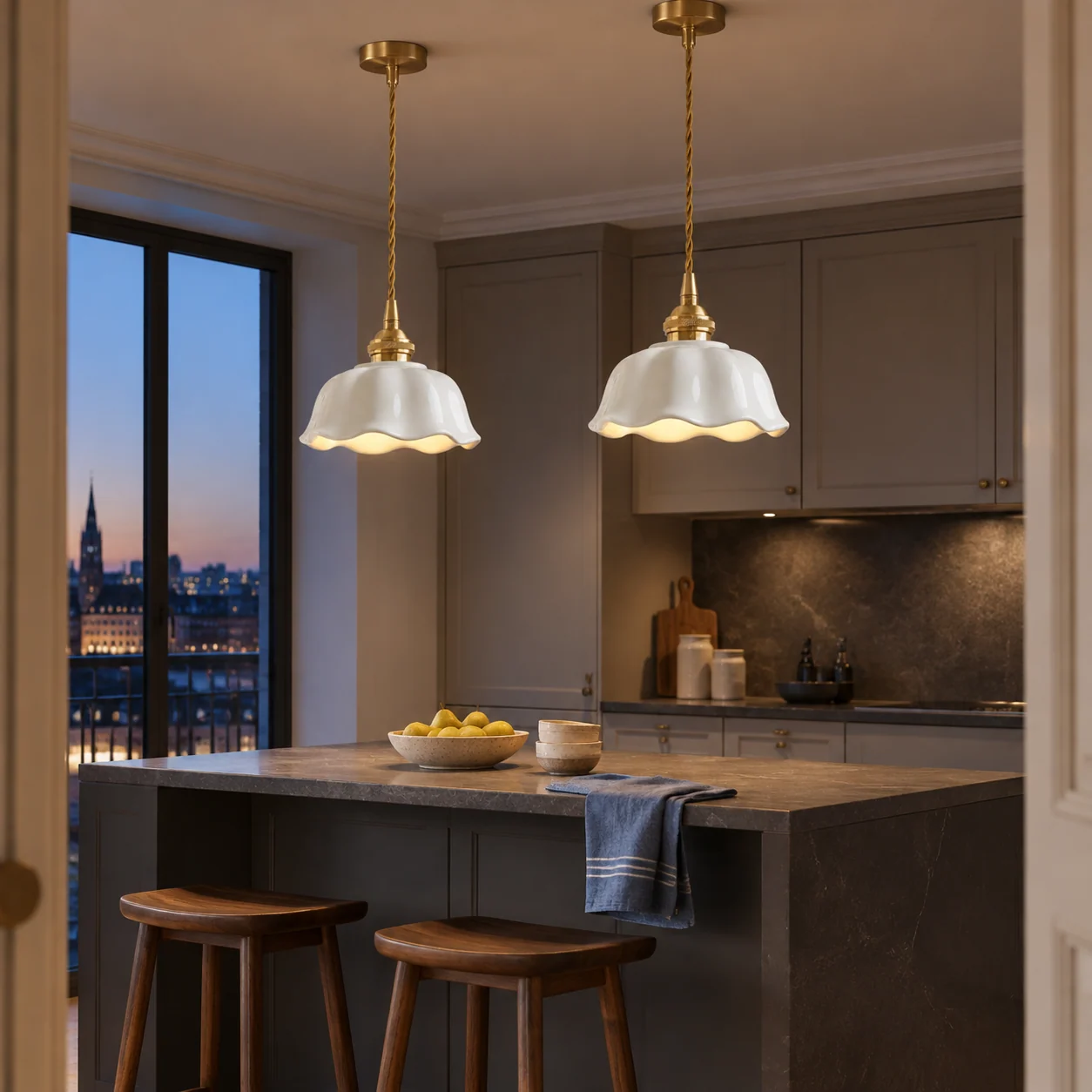Two matching ceramic flower pendants over a kitchen island at blue hour