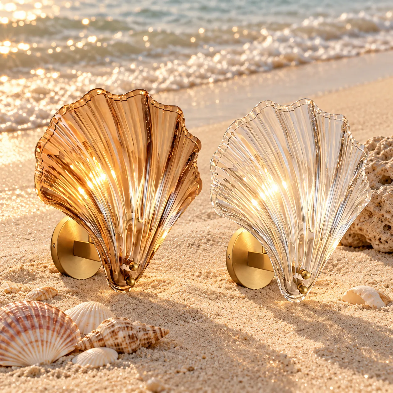 Amber and transparent Vale shell wall lights among seashells on a beach