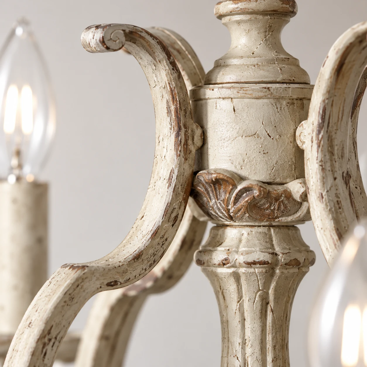 Close view of a curved wood arm joint and dark rubbed carved accents