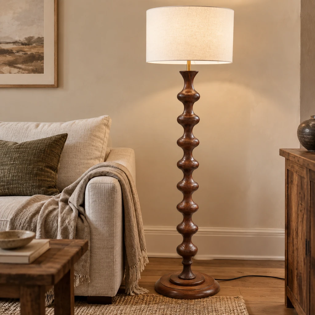 Avery sculpted walnut wood floor lamp beside an oatmeal sofa