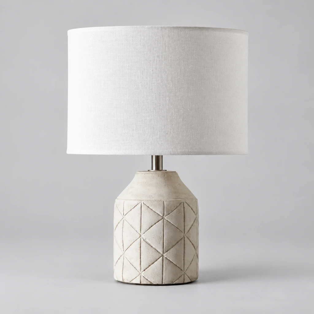 Merritt Geometric Carved Wood Table Lamp with White Drum Shade switched off in a neutral studio