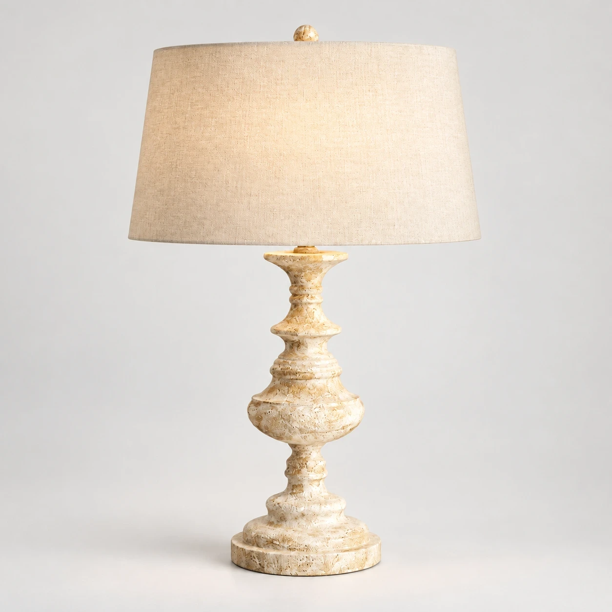 Theo Vintage Bedside Walnut Wood and Metal Table Lamp switched on in a neutral studio