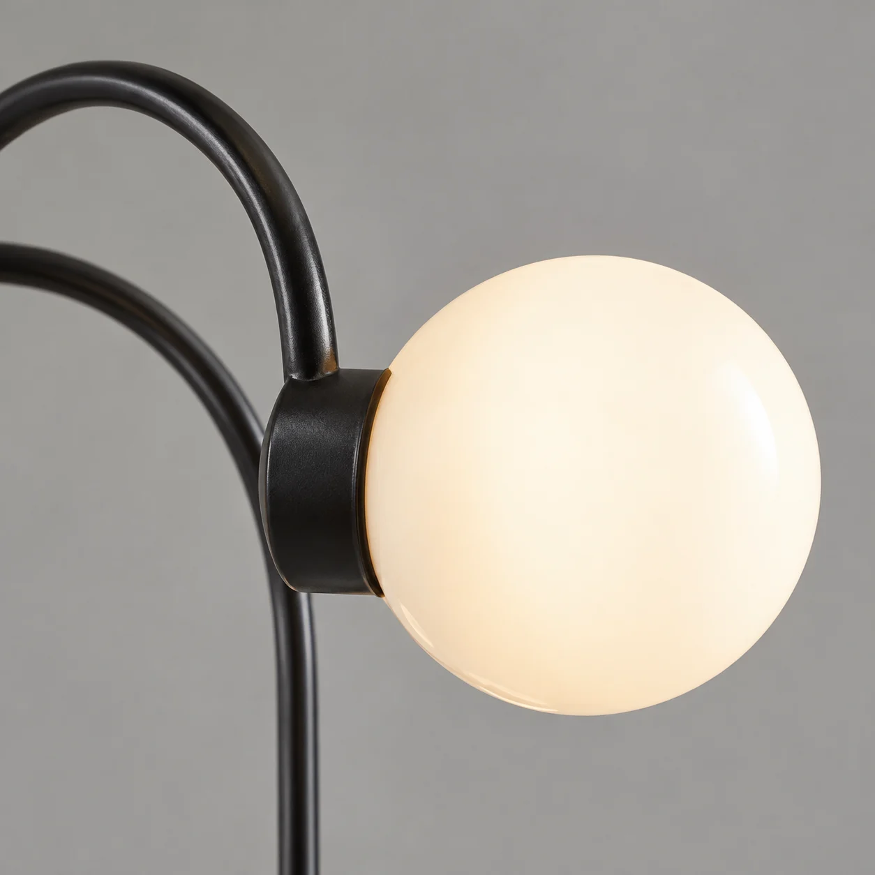 Curved black arm and glass globe connection detail