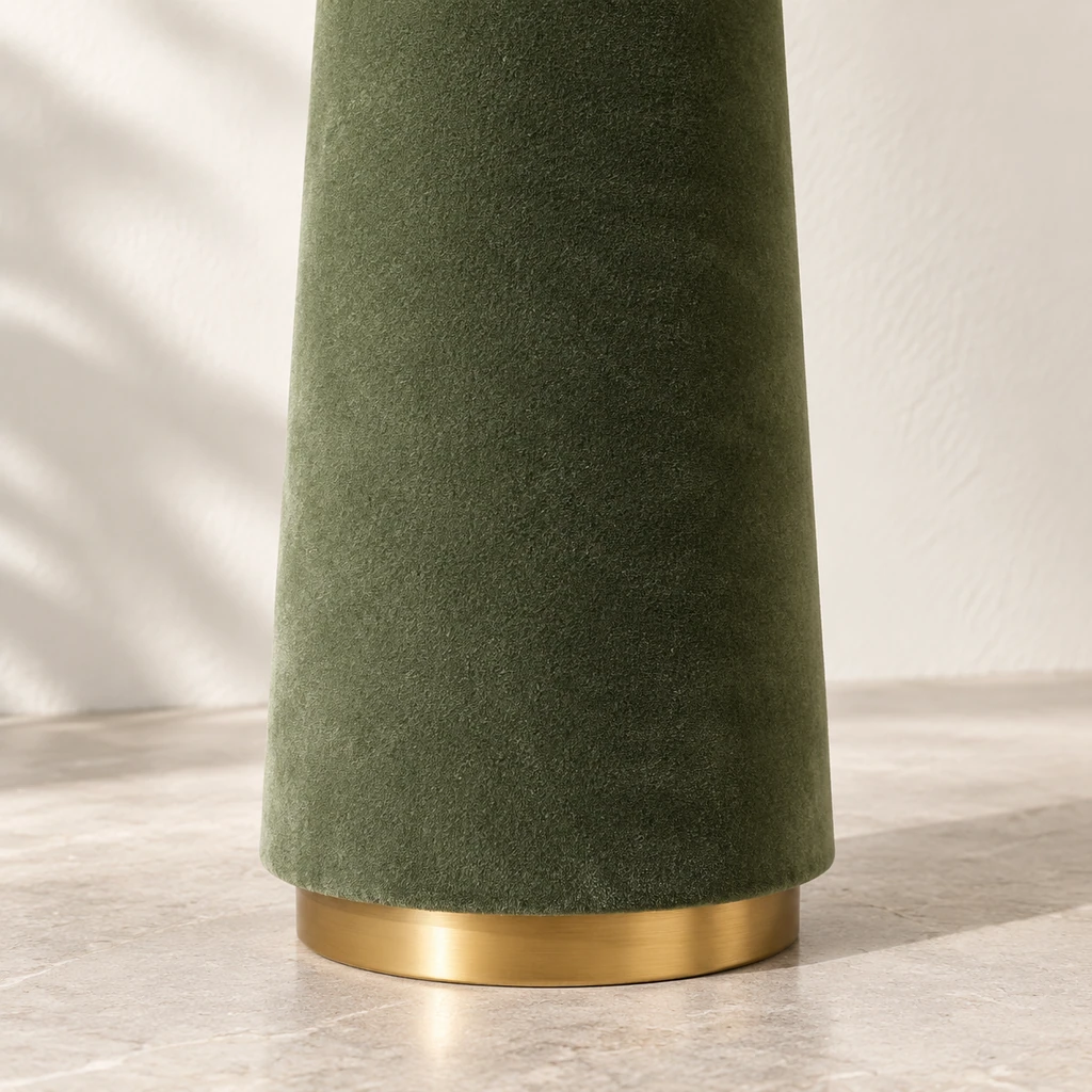 Close detail of the tapered velvet pedestal and brass-tone floor ring