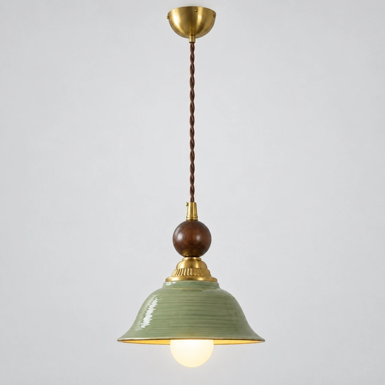 Vintage Green-Glazed Ceramic Pendant Light switched on in a neutral studio setting