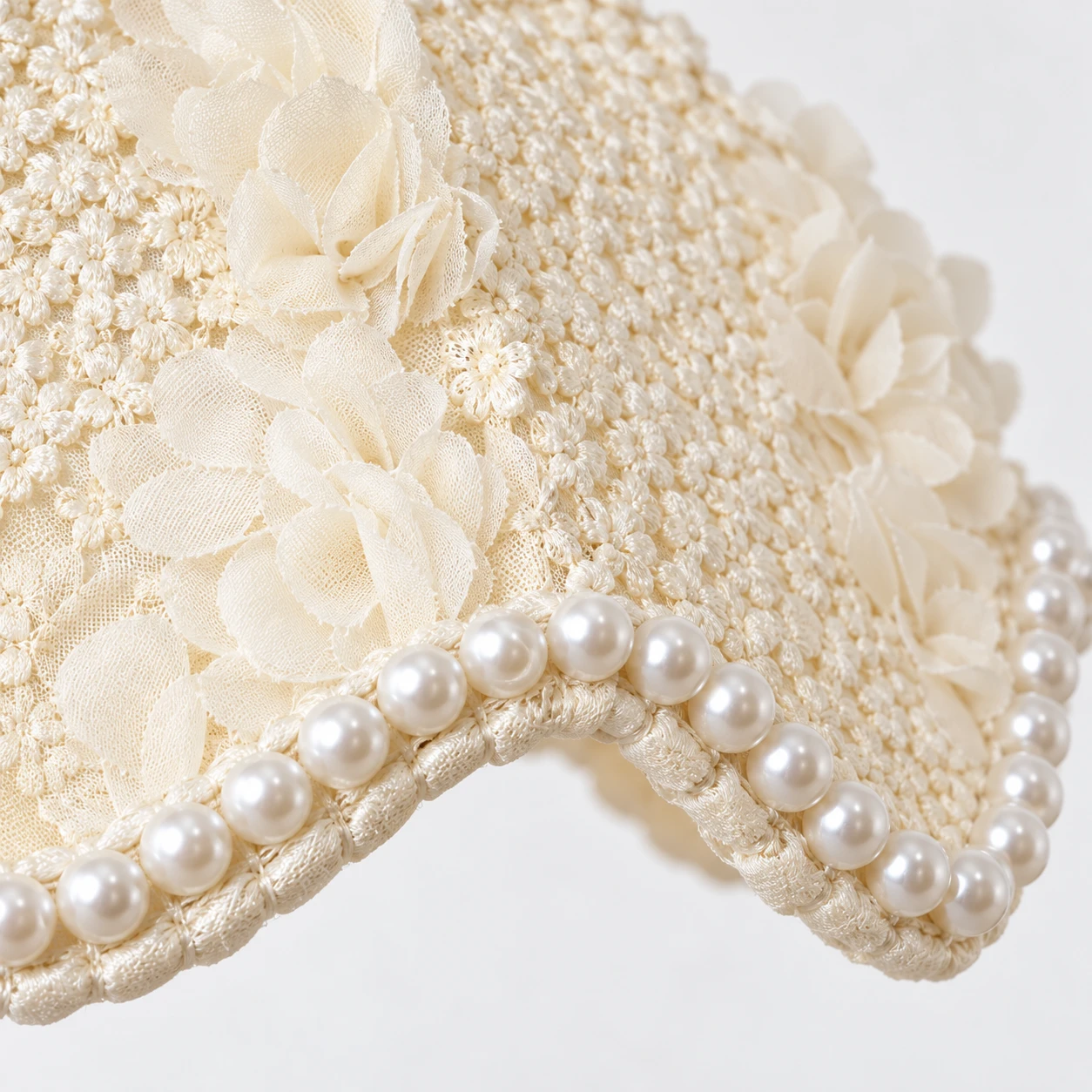 Close-up of ivory floral fabric shade and pearl rim