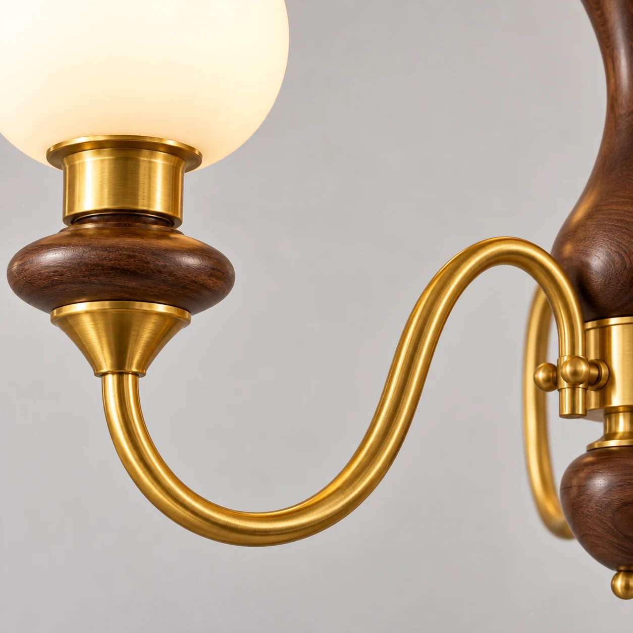 Close-up of curved brass arm and wood cup junction