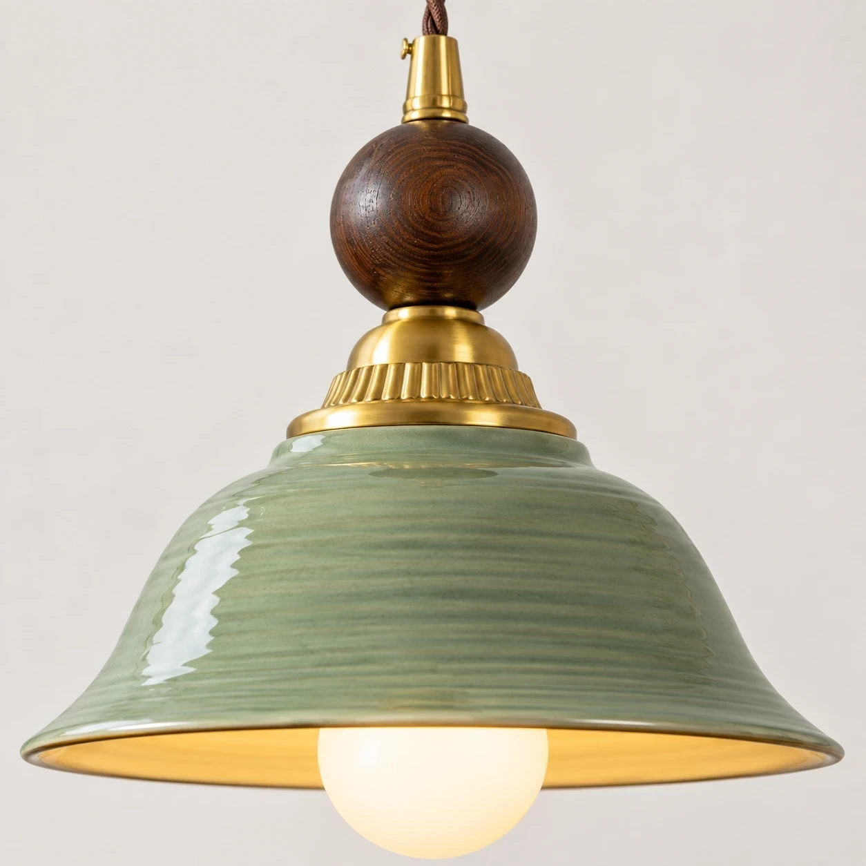 Close view of the green glazed ceramic shade and brass-toned connector