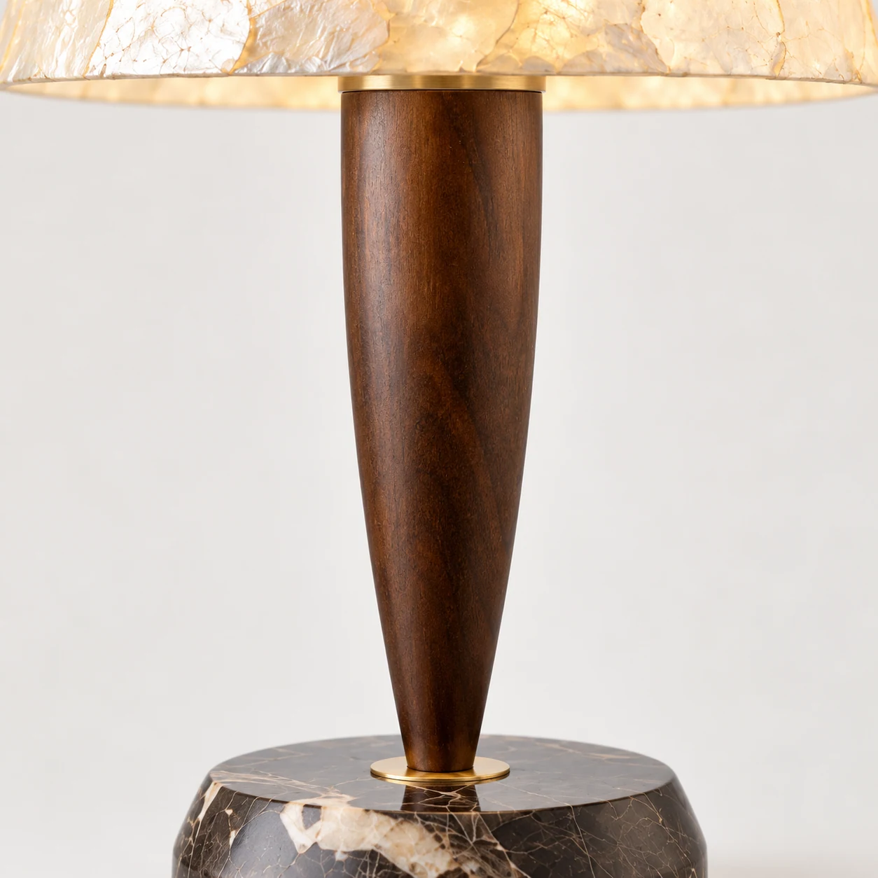 Close view of the tapered solid-wood stem and brass-tone trim rings
