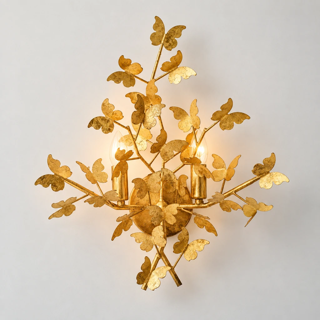 Nora gold-leaf butterfly wall light illuminated in a neutral studio