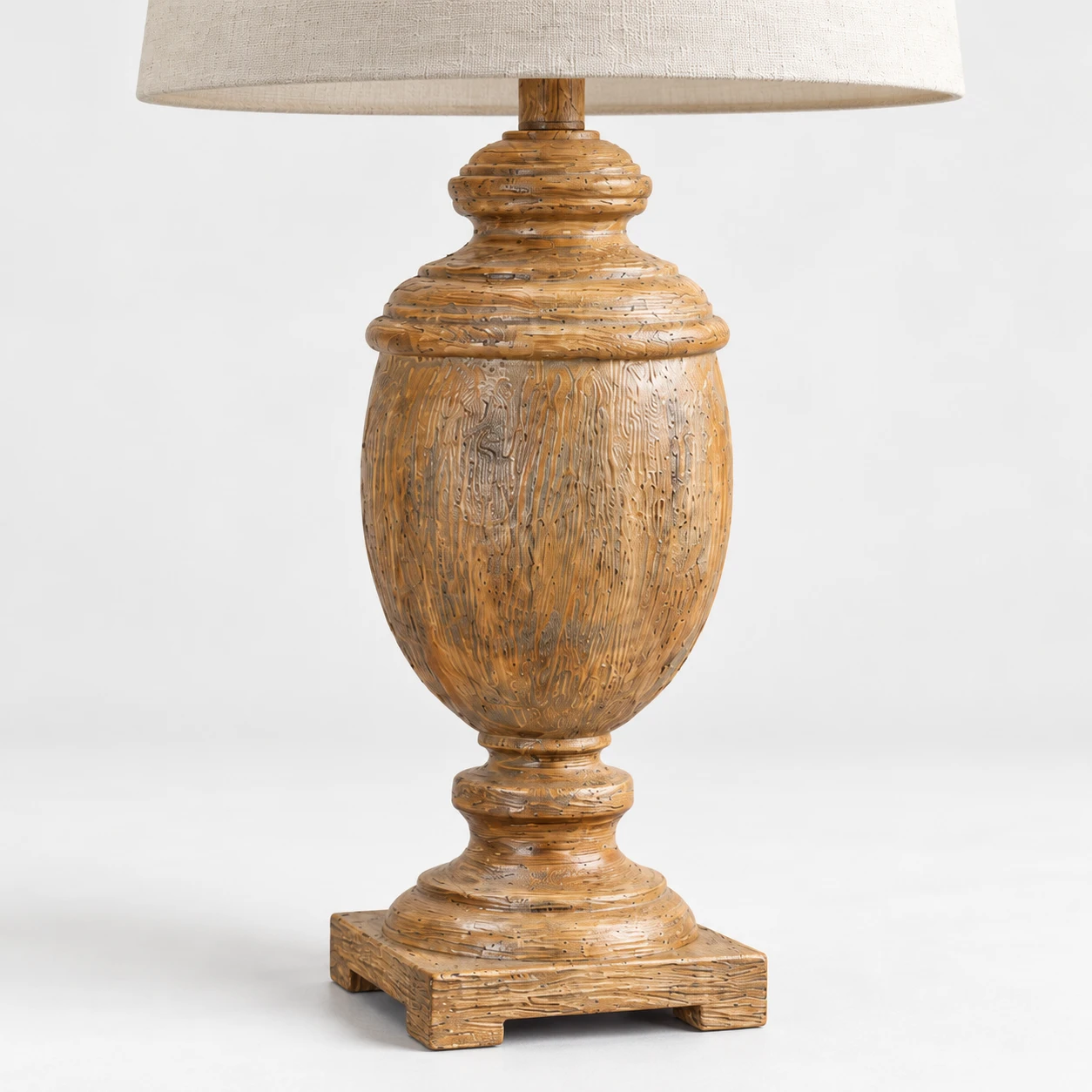 Close detail of the distressed turned solid-wood urn body