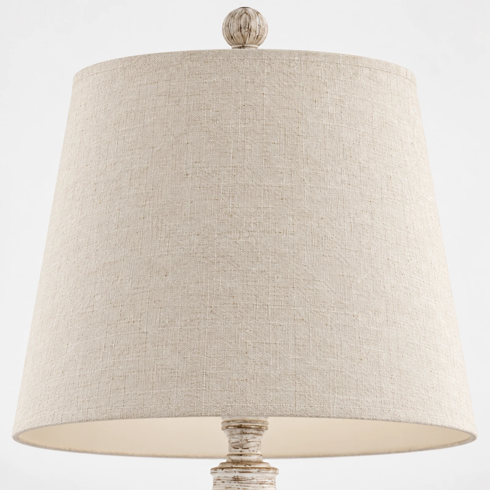 Close detail of the cream tapered fabric shade and wood ball finial