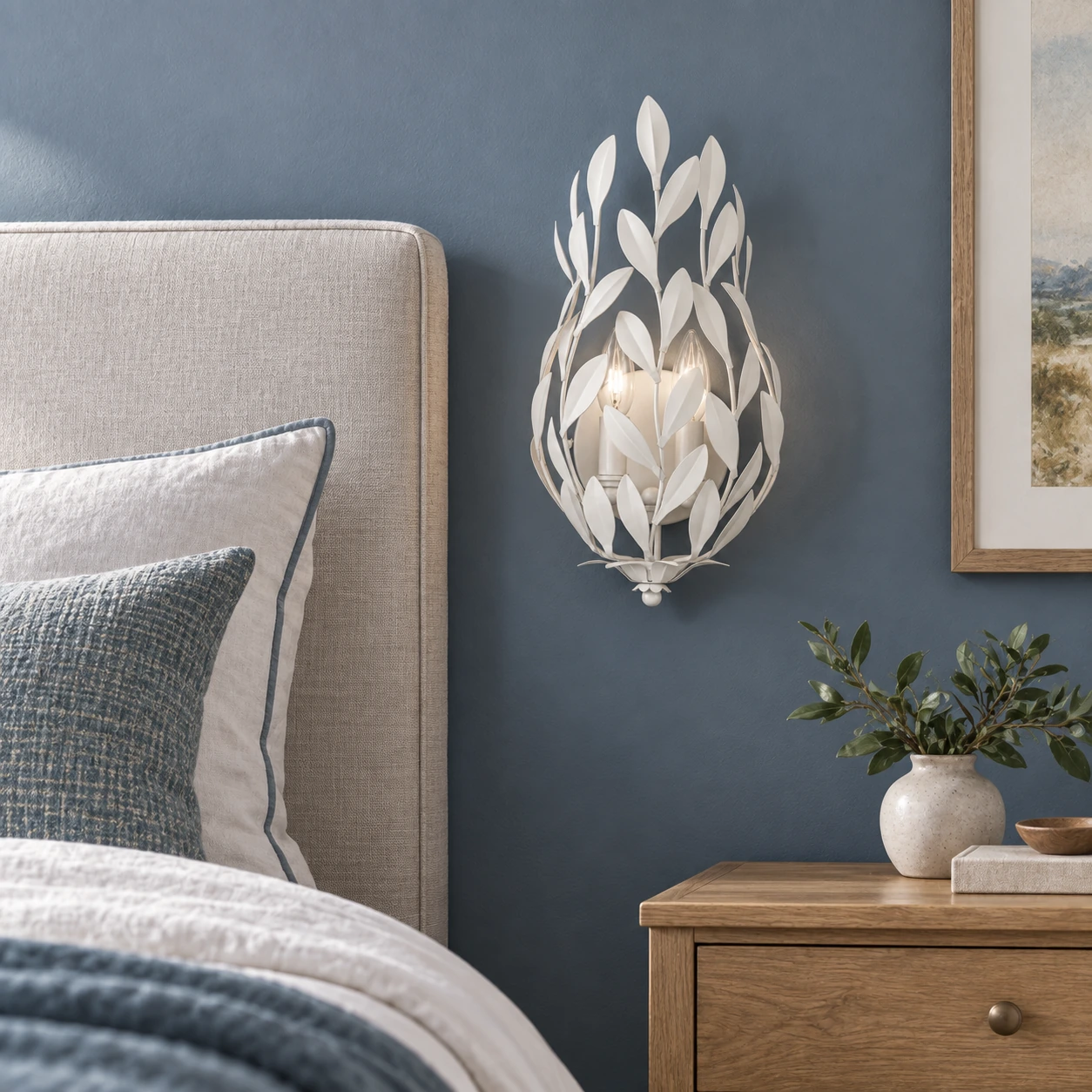 White leaf wall sconce installed beside an upholstered bed
