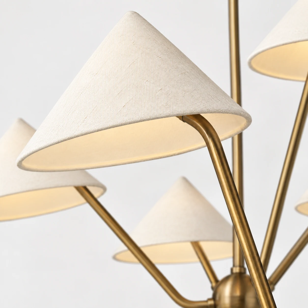 Close view of the pale fabric shade and antique-toned iron arm
