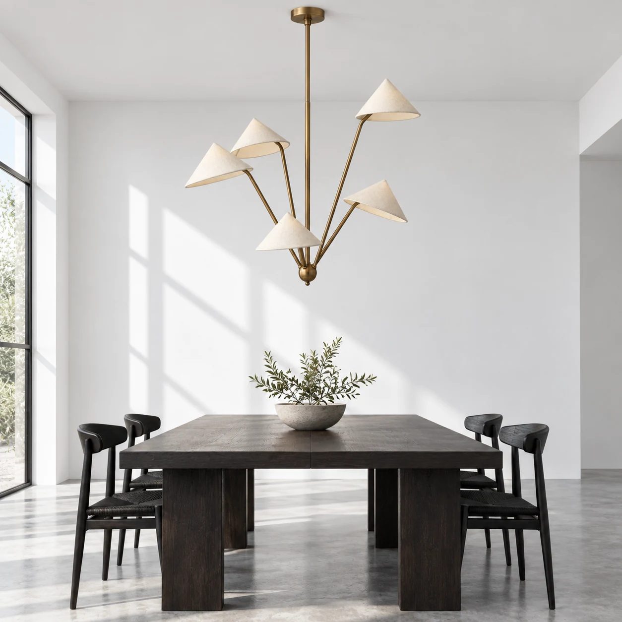 Pendant centered above a dining table in a bright architectural room