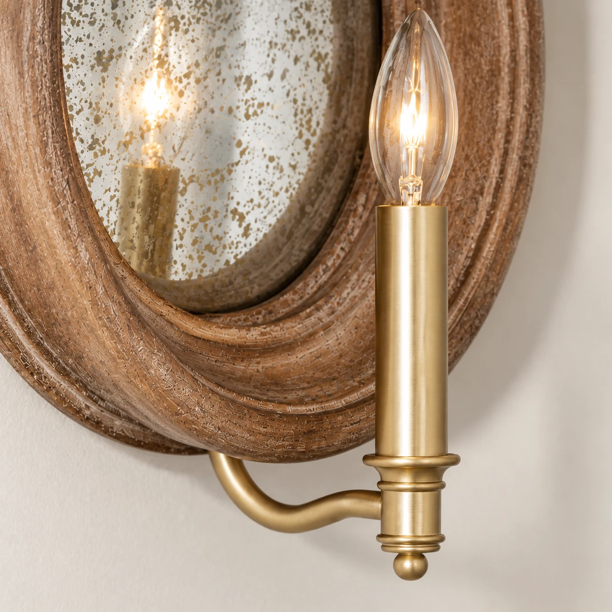 Close view of the brass candle sleeve, curved arm and ball finial