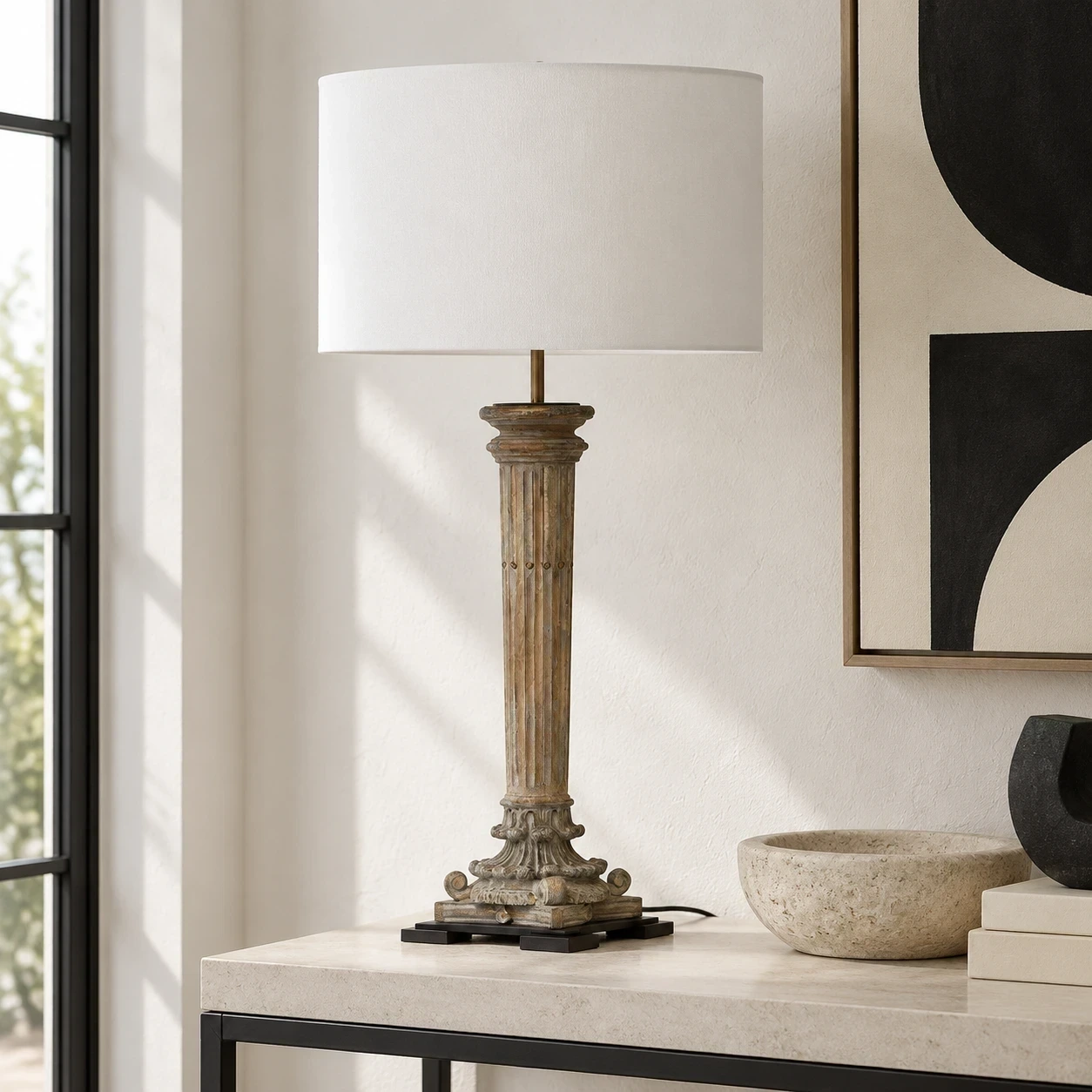 Aveline carved wood table lamp on a limestone console in a neutral interior