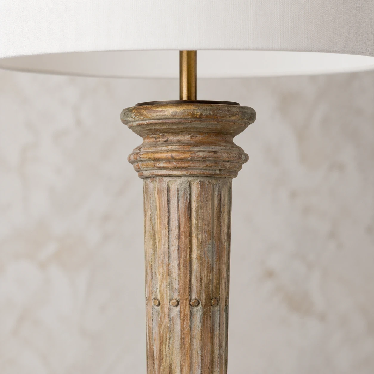 Close detail of the upper carved wood column and layered collar