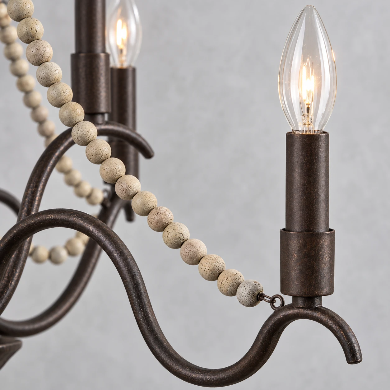 Dark iron branch, candle sleeve and natural wood beads in close detail