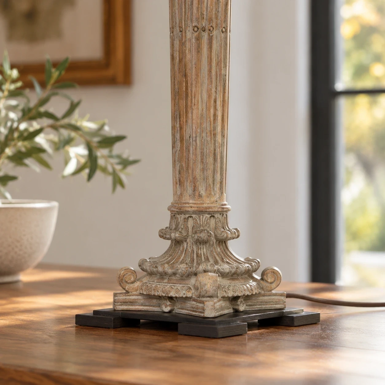 Close detail of the ornamental lower carving and dark square base on a tabletop