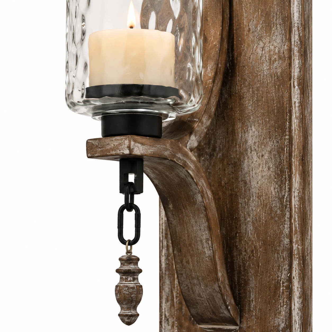 Close view of the clear glass candle cup, chain and carved finial
