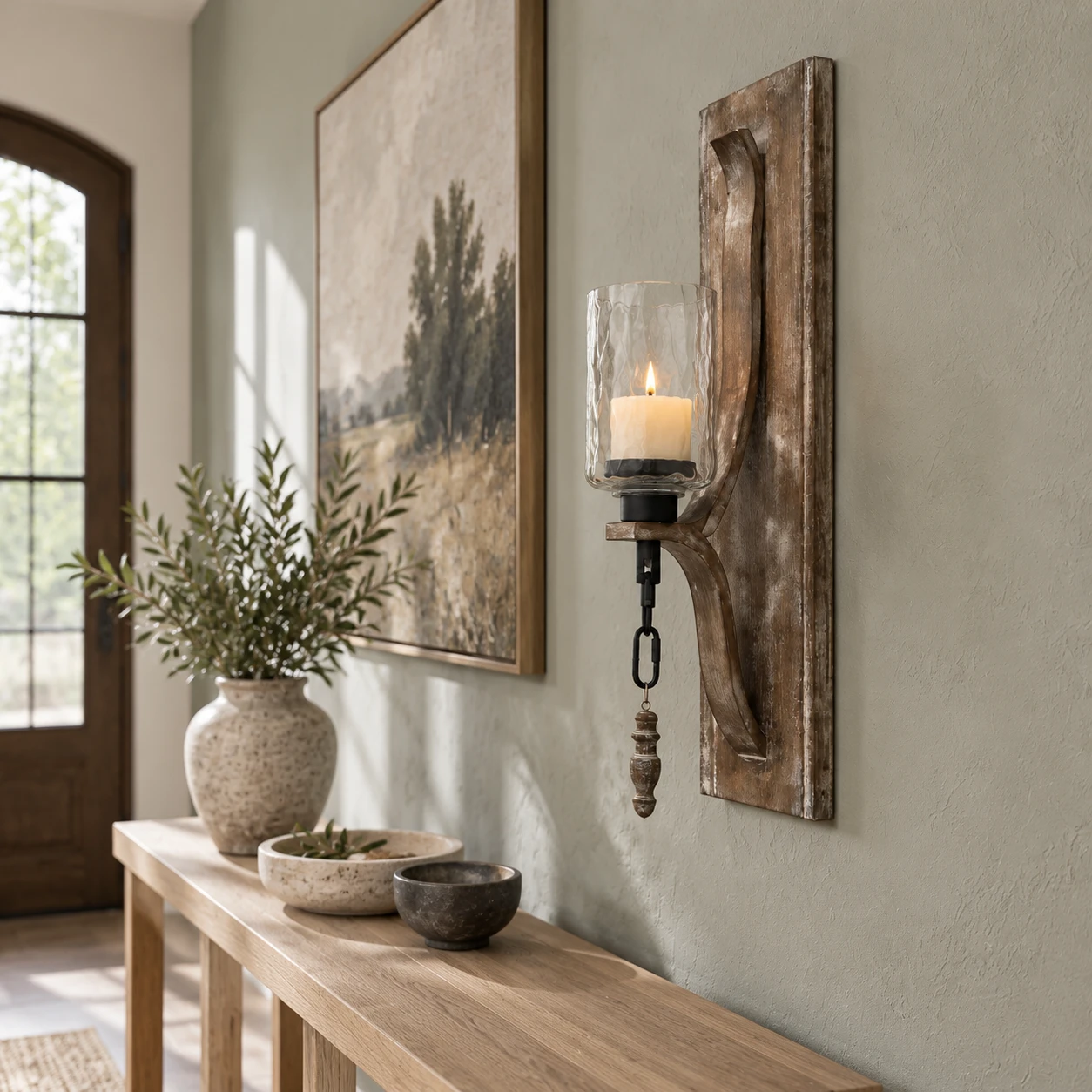 Carved wood candle holder with glass cup mounted flush to an entry wall