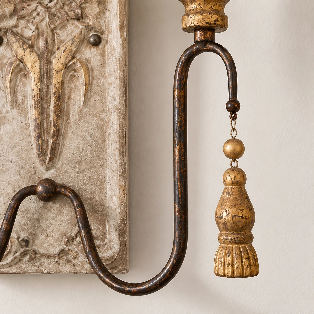 Oxidized iron arm and antiqued-gold tassel ornament