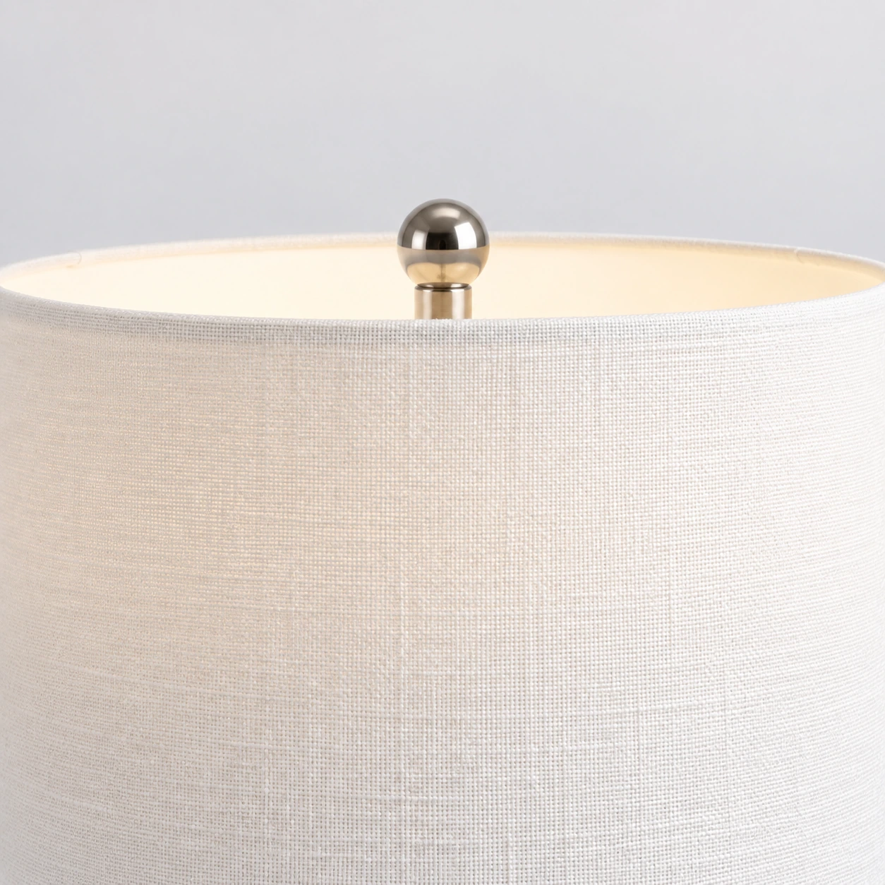 Close detail of the Odette lamp white woven shade and chrome-toned ball finial