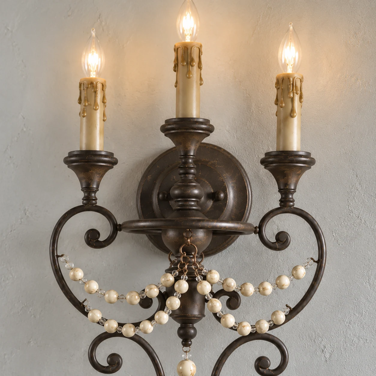 Close view of the three candle-style stems, curved frame and bead drapes
