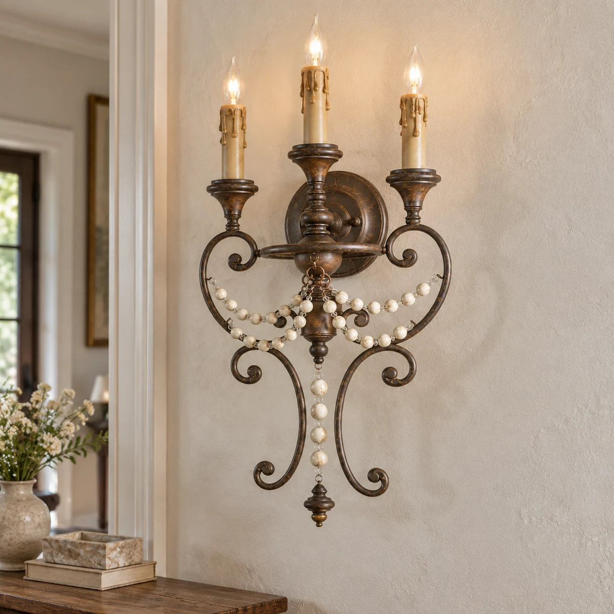 Three-light beaded wall sconce mounted beside a residential entry