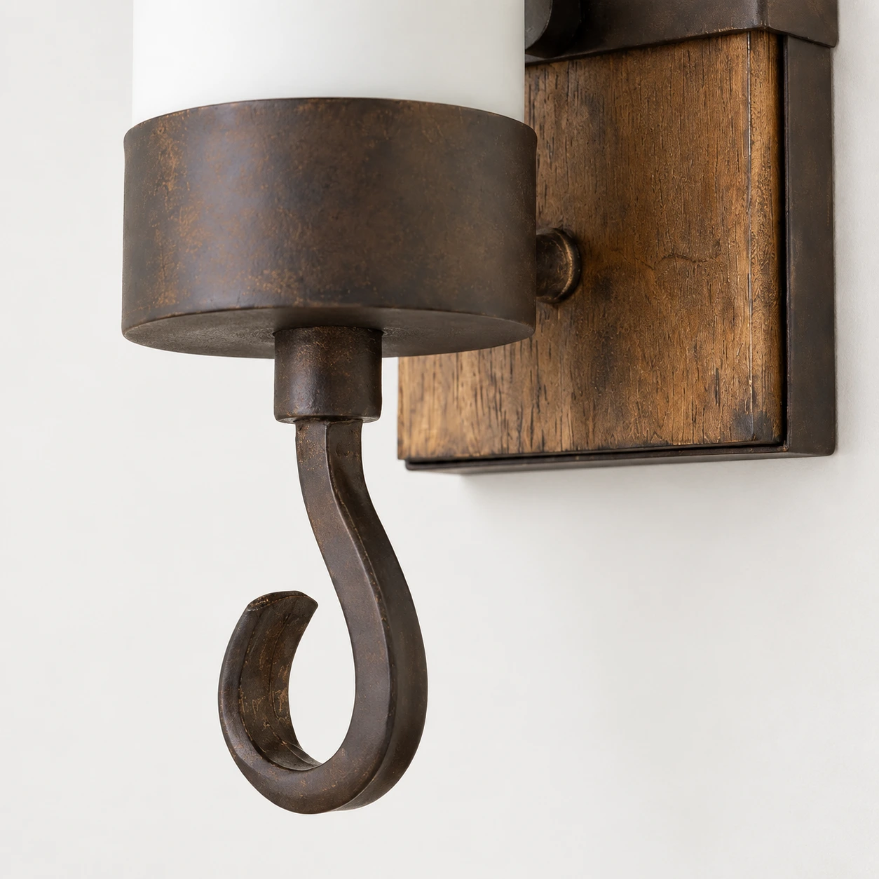 Close detail of the curved aged metal lower hook and its connection