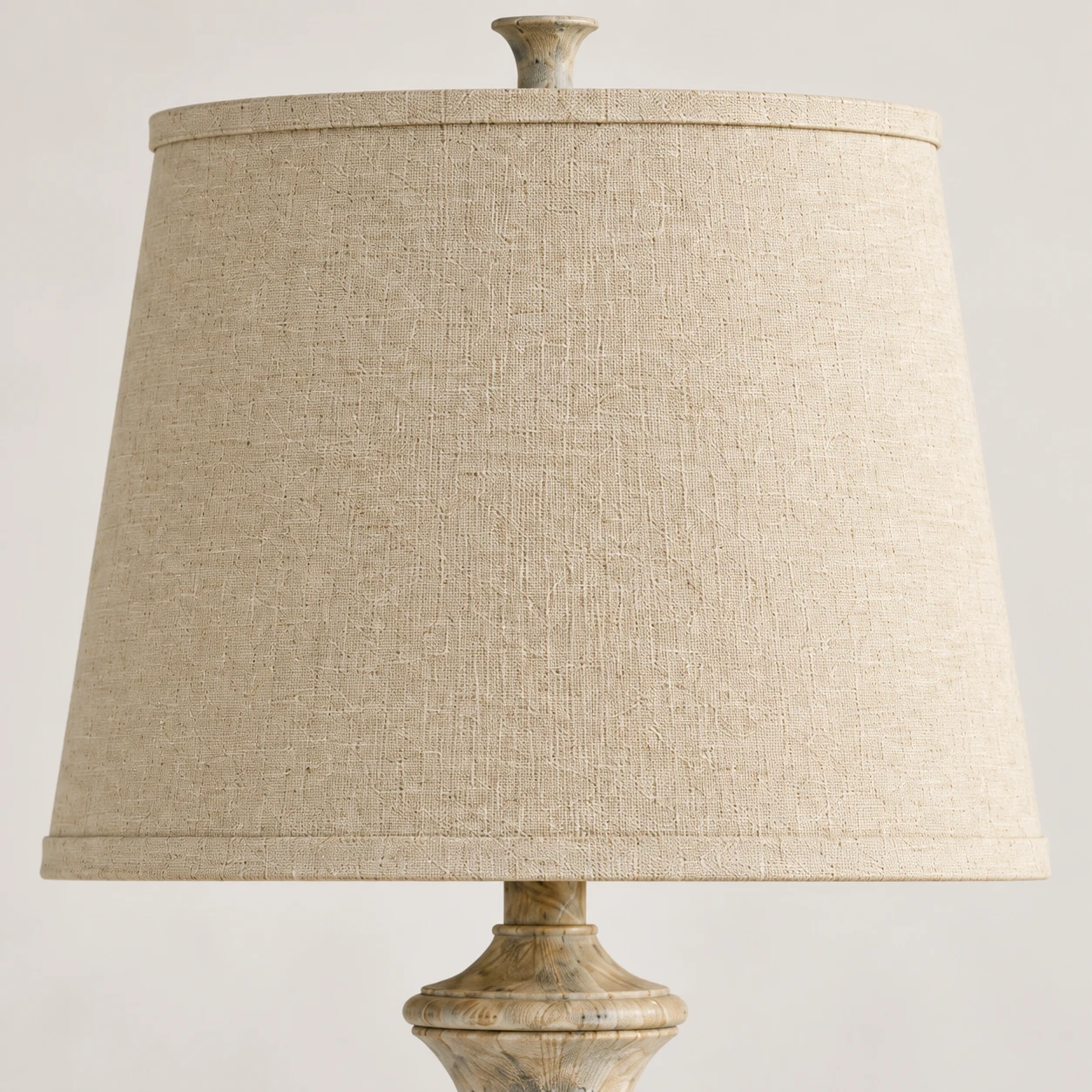 Fabric drum shade and finial detail of the carved wood table lamp