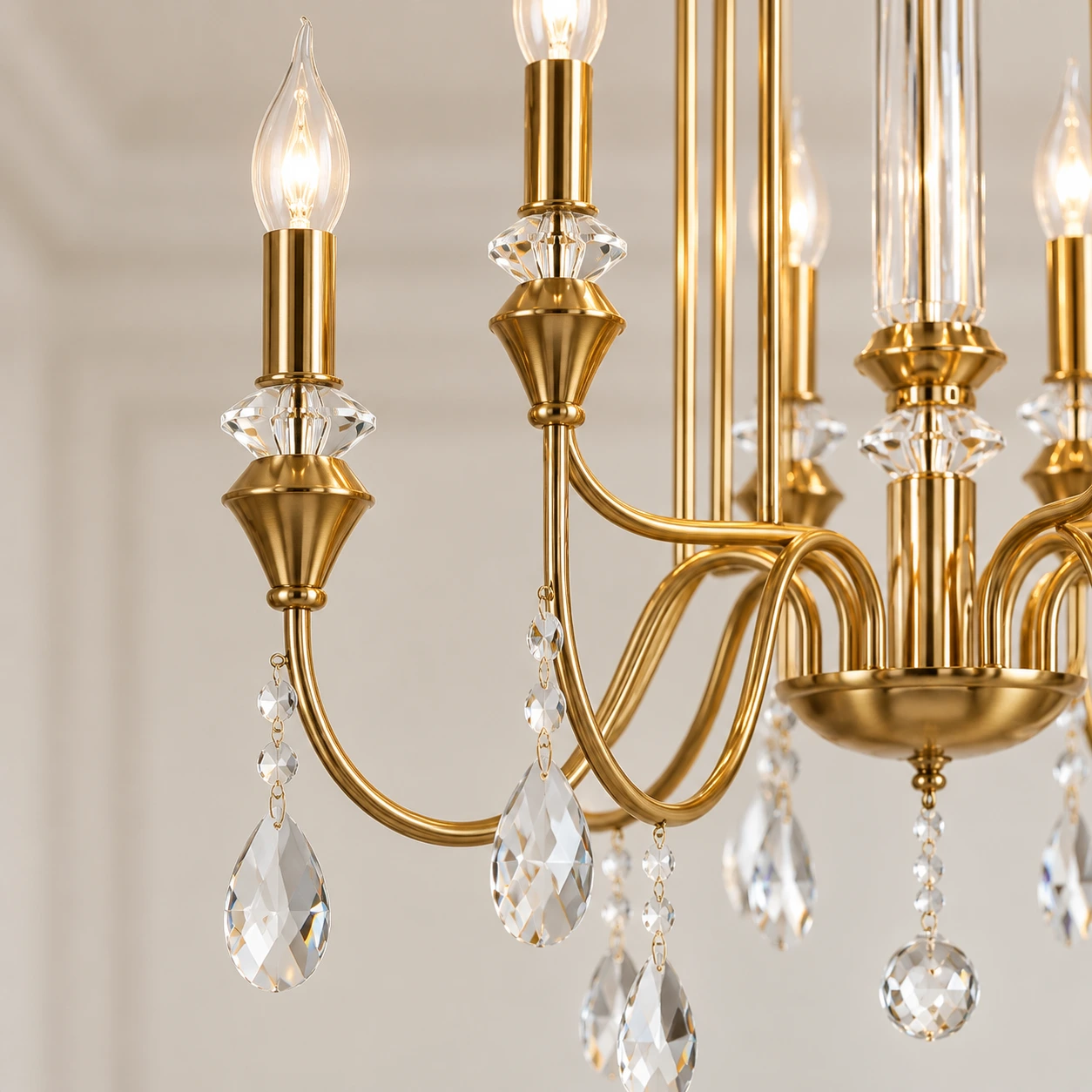 Close view of a curved chandelier arm, candle socket and crystal drops