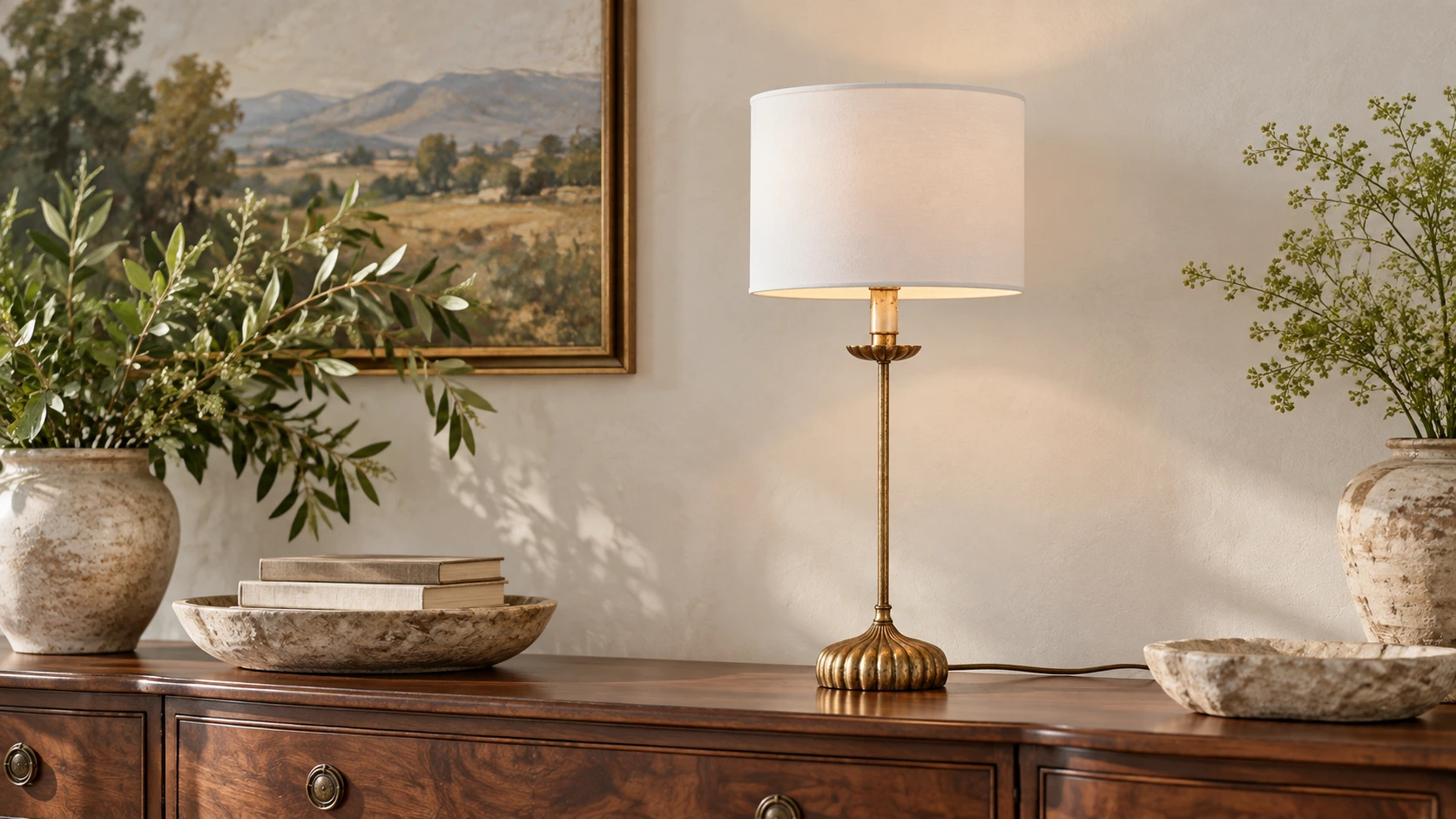 Distressed antique-gold table lamp on a walnut console